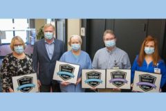 Hamilton leadership holding award plaques from CareChex with CEO Jeff Myers