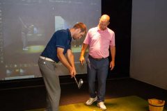 Golf instructor Brian Smith at Hamilton Spine health and sport give a golf lesson in the Full Swing golf simulator