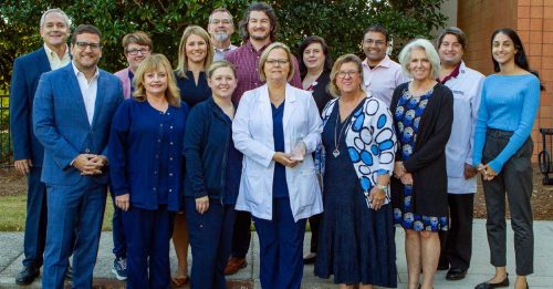 Hamilton leadership poses with the WHite Coat award