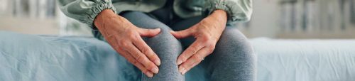 senior woman holding knee from pain caused by Osteoarthritis and Plantar Fasciitis.