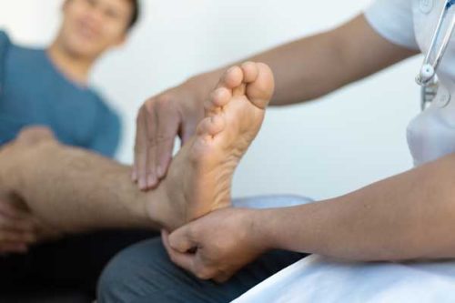 doctor holding foot to treat pain caused by Osteoarthritis and Plantar Fasciitis at peeples cancer institute in dalton, ga