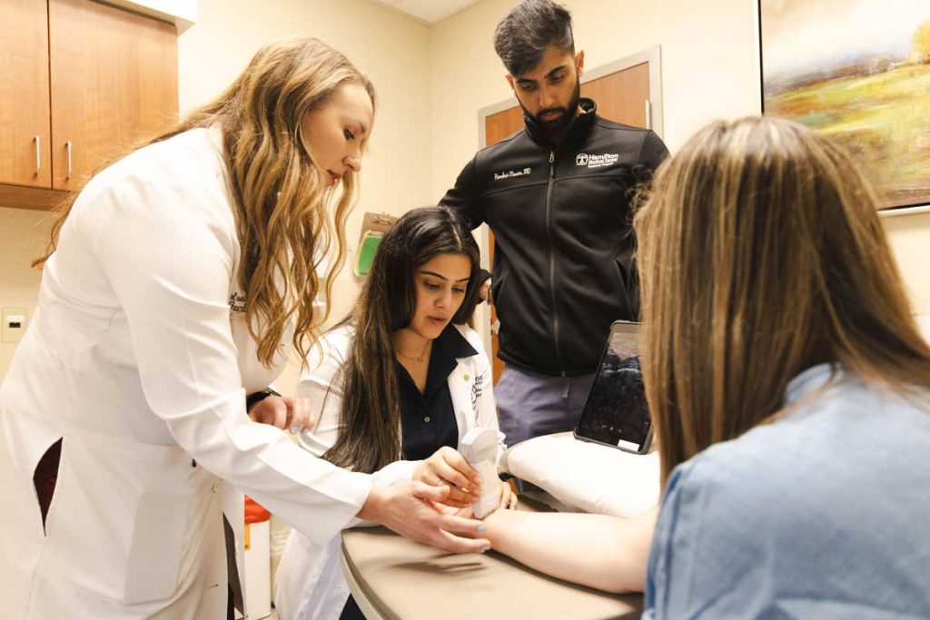 attending physician with residents and ultrasound
