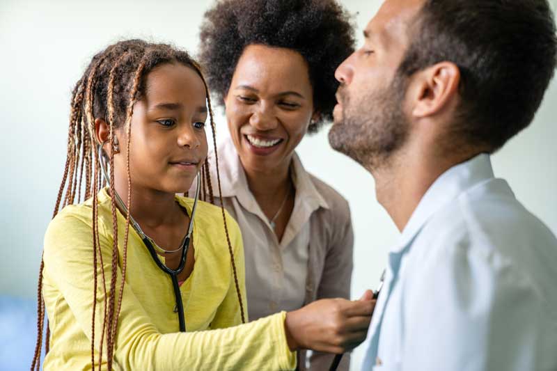 young girl uses stethoscope to exam doctor