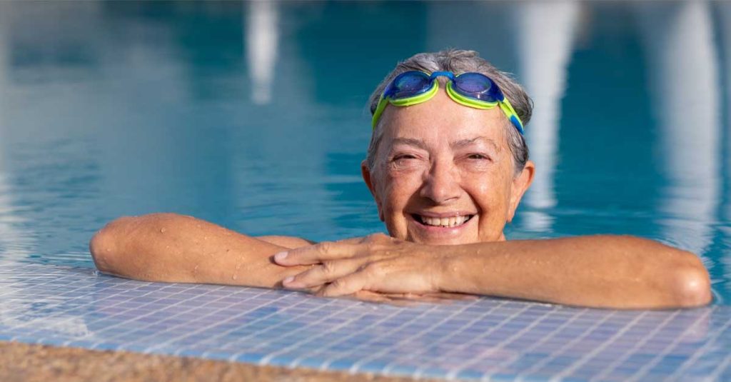 senior woman on pool's edge smiling